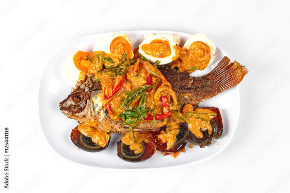 Curry-fried  tilapia fish with preserved egg and salted egg as topped a spicy curry with coconut milk.
