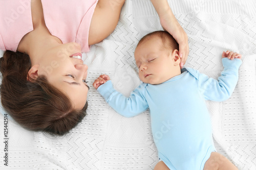 Young woman and her baby ly...