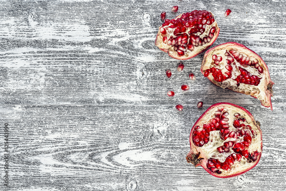 Fresh juicy cut pomegranate on a wooden gray background. Free sp Fresh juicy cut pomegranate on a wooden gray background. Free sp