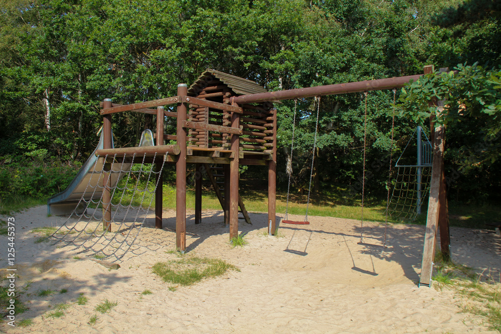 Wooden playground equipment with slides at summer time Wooden playground equipment with slides at summer time