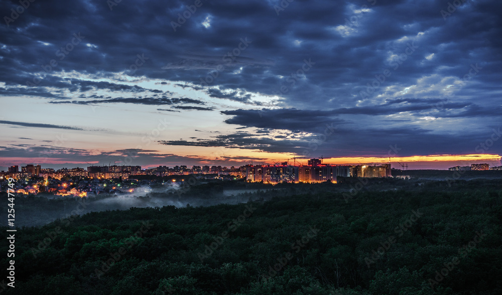 Obraz premium City sunset, beautiful sky and forest in the foreground