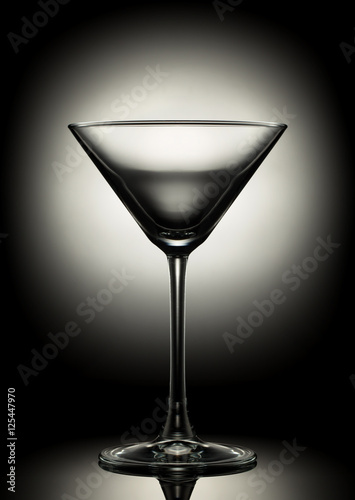 Empty martini glass on a color background.