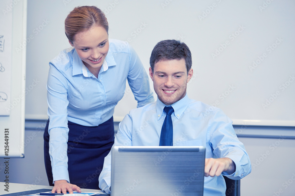 smiling businesspeople with laptop in office smiling businesspeople with laptop in office