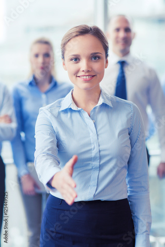 smiling businesswoman making handshake in office Free Download smiling businesswoman making handshake in office - GFXLoad