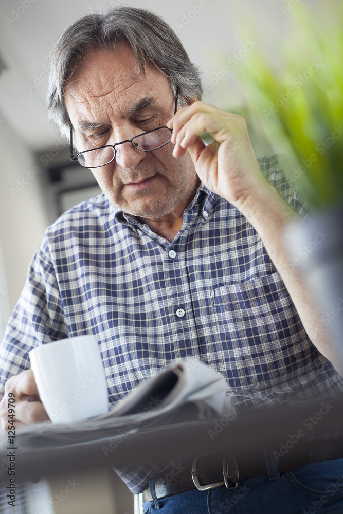 Man reading newspaper on table Man reading newspaper on table