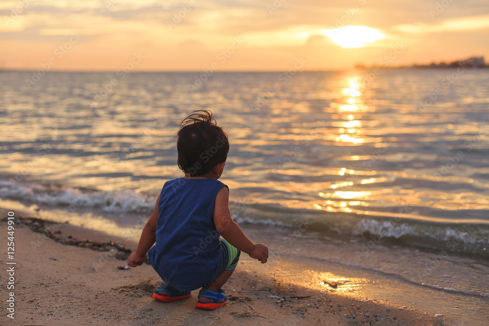 Little boy play on beach at sunset Little boy play on beach at sunset