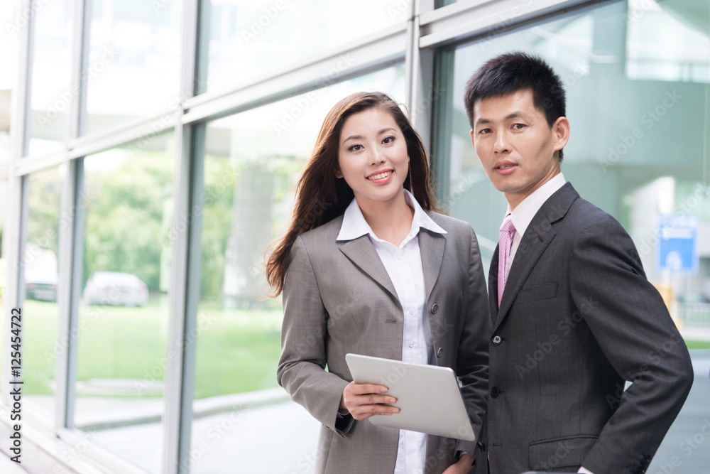 asian beautiful girl and businessman with tablet in modern hall asian beautiful girl and businessman with tablet in modern hall