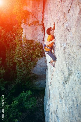 male rock climber. rock climber climbs on a rocky wall. man makes hard move