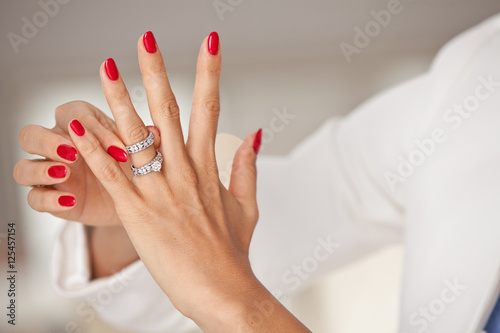 Murais de parede Closeup photo of a beautiful female hands with red nails and ele
