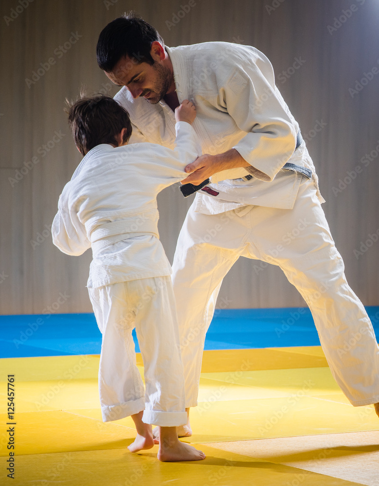 Man and young boy are training judo throw Man and young boy are training judo throw