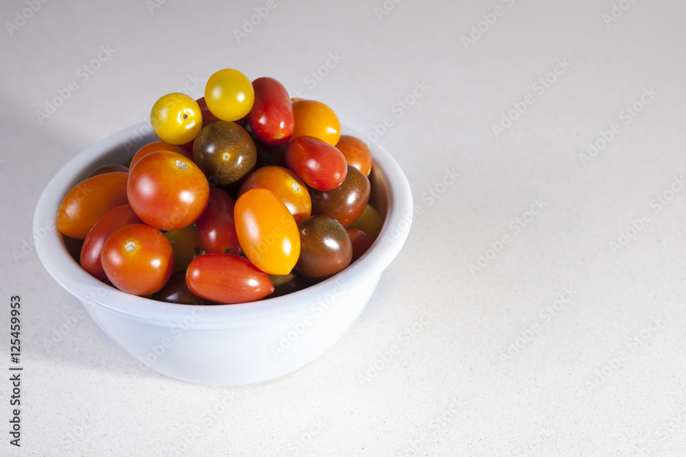 Clay bowl full of several varieties of cherry tomatoes Clay bowl full of several varieties of cherry tomatoes