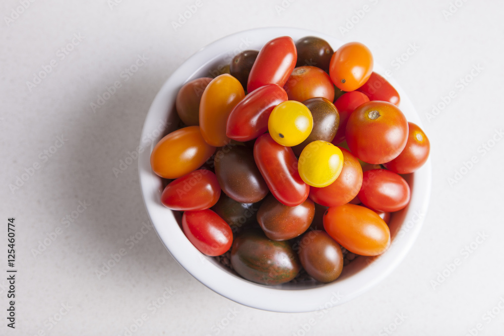 Clay bowl full of several varieties of cherry tomatoes Clay bowl full of several varieties of cherry tomatoes