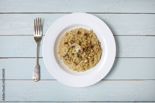 A dinner dish of mushroom and chicken risotto rice on a rustic wooden table top background