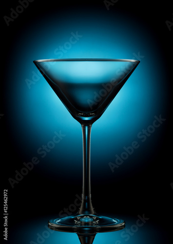 Empty martini glass on a color background.