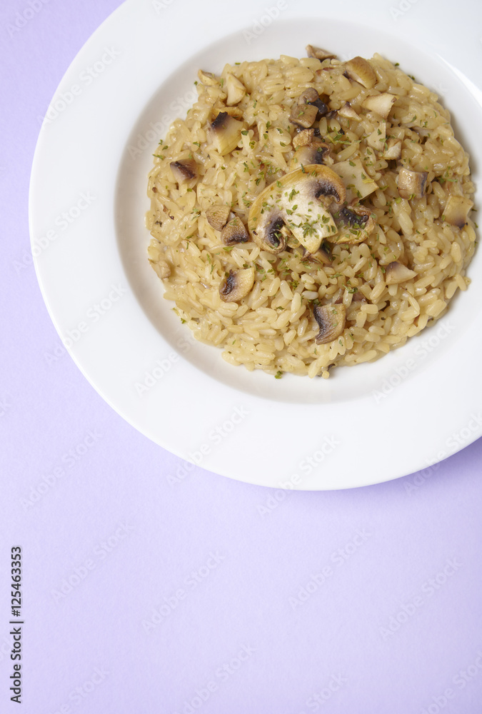 A dinner dish of chicken and mushroom risotto on a pastel purple background forming a page header