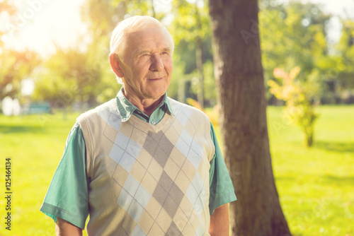 Senior man outdoors. Old guy slightly smiling. Purity of reason. Wisdom comes with time.