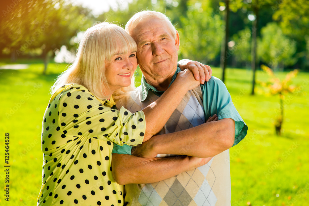 Senior woman hugging man. Smiling couple outdoor. Live a happy life together. We value each other. Senior woman hugging man. Smiling couple outdoor. Live a happy life together. We value each other.
