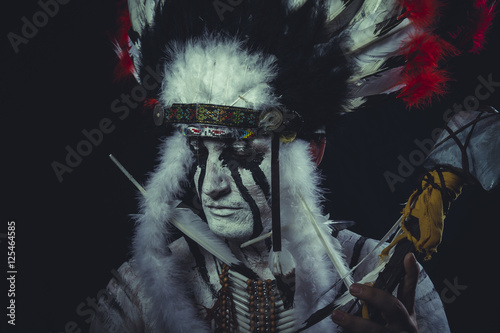 American Indian chief with feather headdress and traditional war