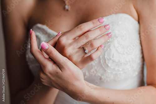 Young bride showing her ring with hand on her chest. Close up.