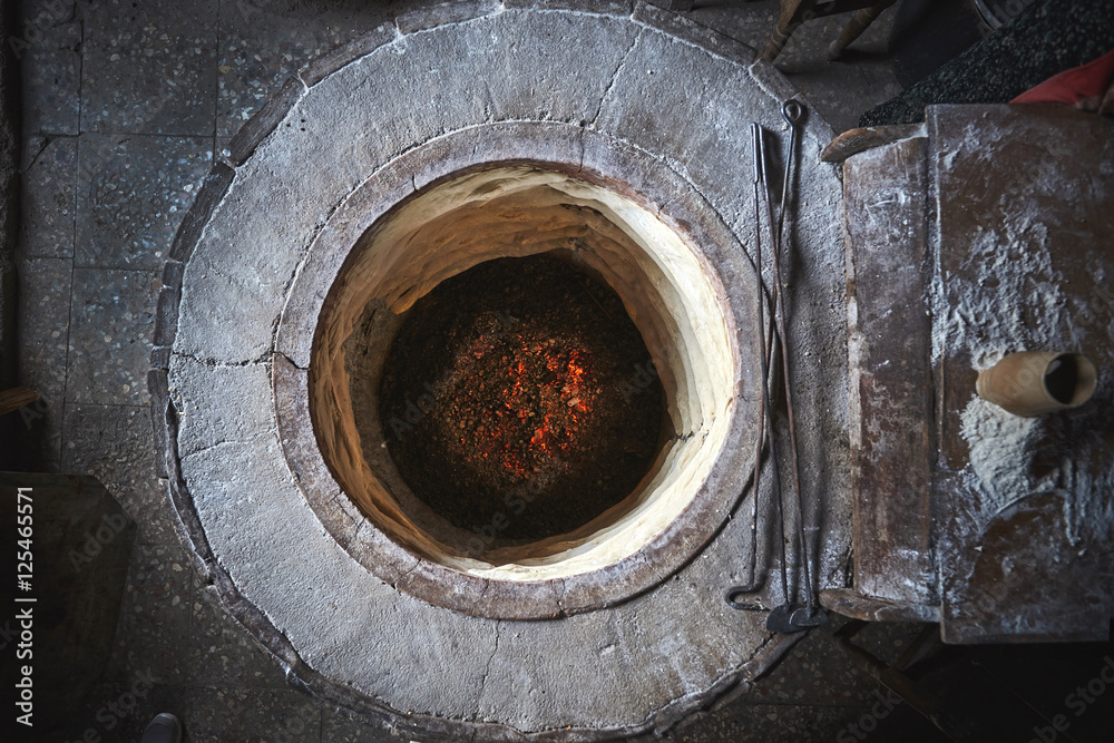 Круглая каменная печка в которой печется домашний хлеб в грузинской деревне