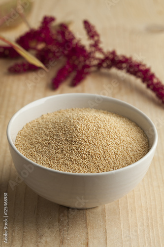Fotografie Bowl with amaranth seeds and a twig with flowers