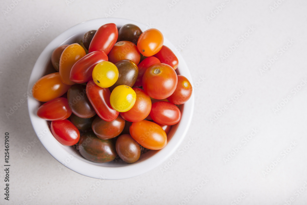 Clay bowl full of several varieties of cherry tomatoes Clay bowl full of several varieties of cherry tomatoes