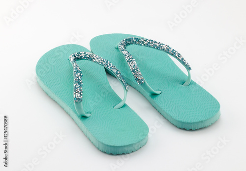 Pair of sea green flip flops with crystal embellishment isolated on white background