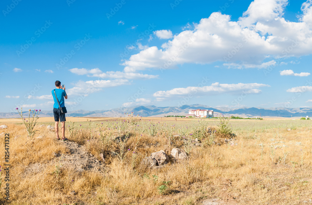 Young man is taking a photo of picturesque place