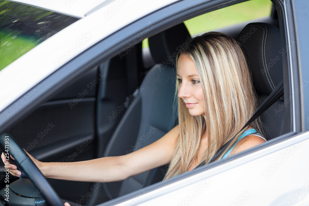 Young woman concentrates on driving her vehicle