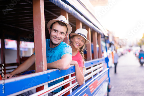 Traveling Asia. Young handsome man with his girlfriend in traditional thai bus. photo