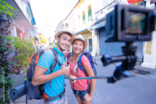 Tourism and technology. Traveling backpacker couple taking selfie on action camera together outdoors.