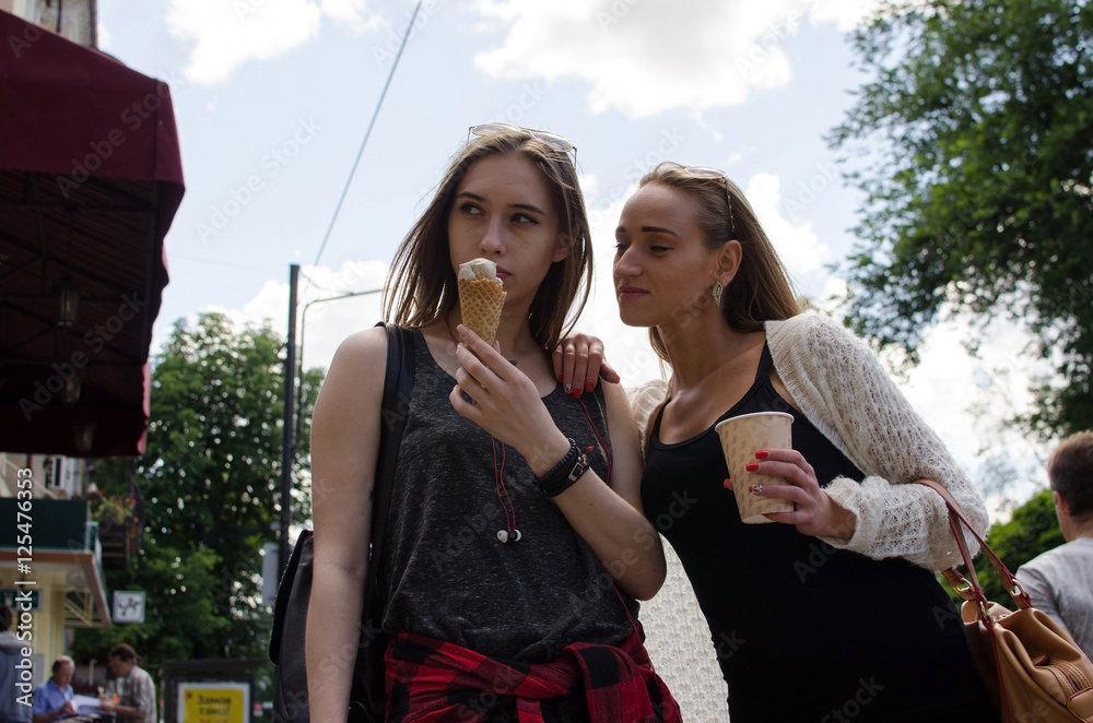 Fototapeta premium Two girlfriends are eating icecream