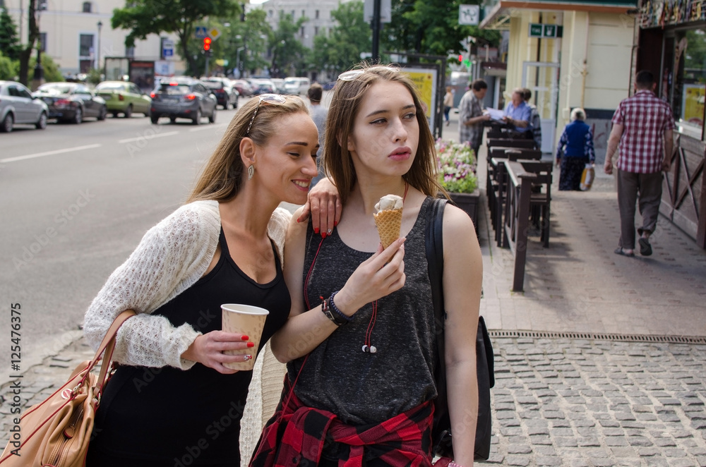 Naklejka premium Two girlfriends are eating icecream