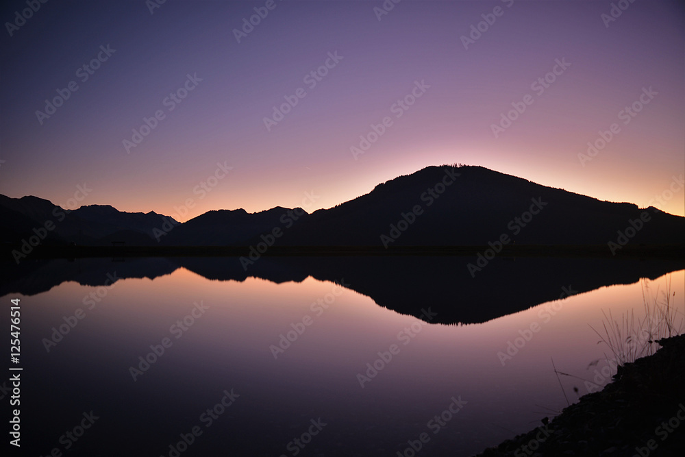 sunset, clear night, the alps reflected in a lake