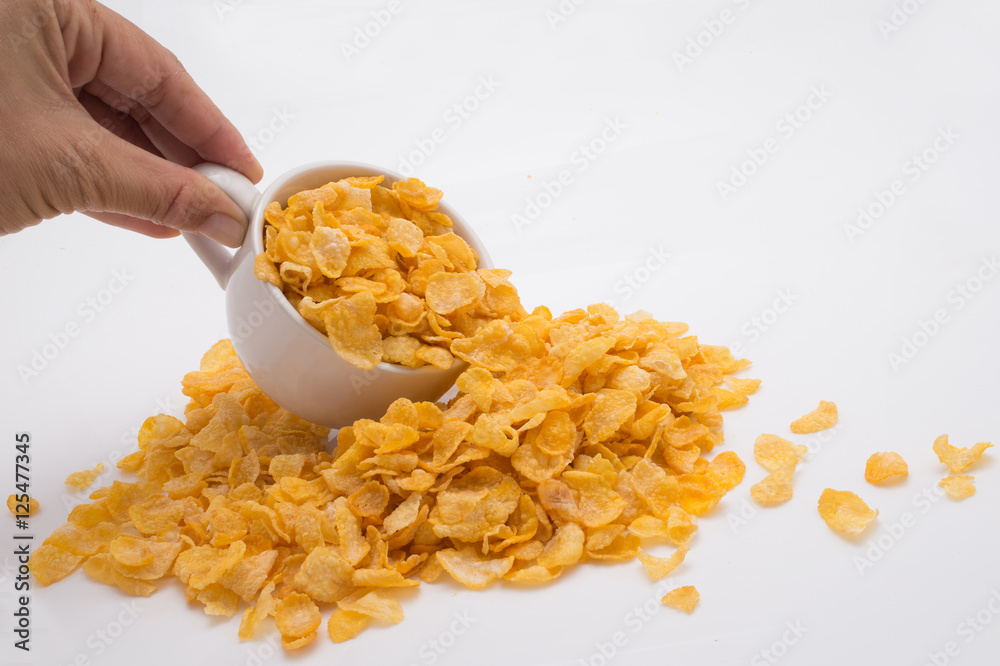 Hand Spilling Corn Flakes out of Tiny Cup Hand Spilling Corn Flakes out of Tiny Cup
