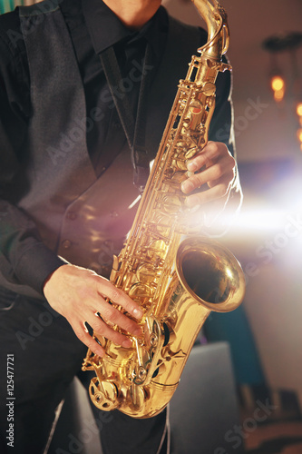 Young man in a suit hold a saxophone musical instrument
