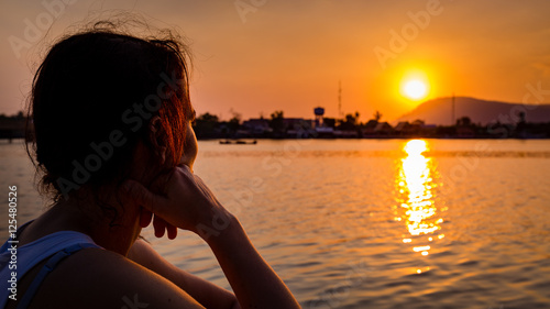 Canvastavla Girl looking into the sunset at a river in Kampot, Cambodia