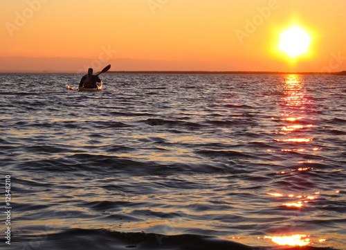 Kayaking at sunset on calm lake