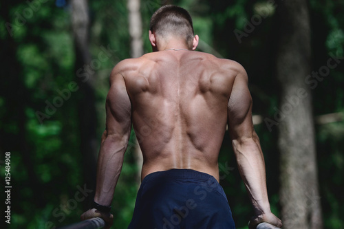 Muscular man practice street workout in an outdoor gym