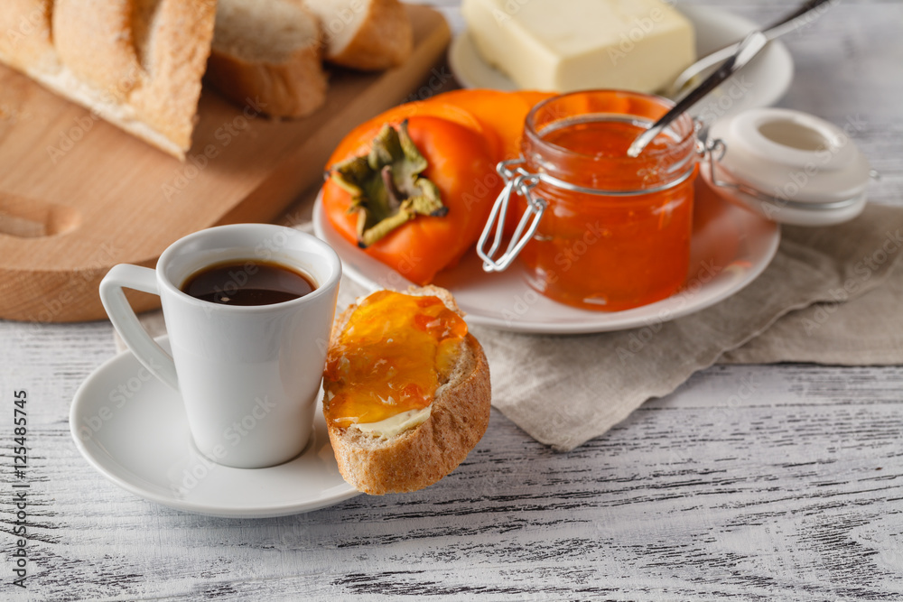 Breakfast with persimmon fruit jam and coffee on wooden table