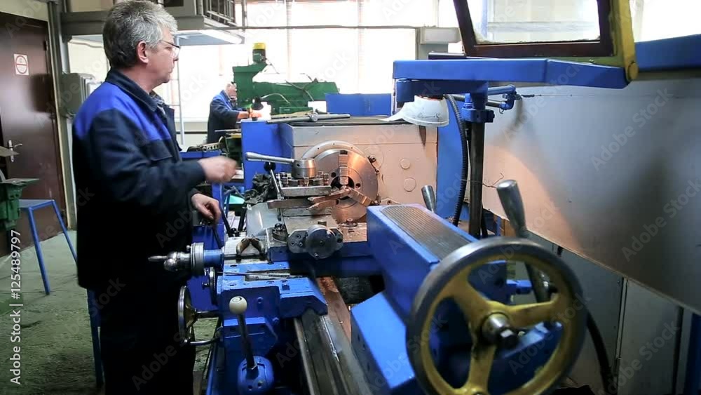 Worker operating in manual lathe