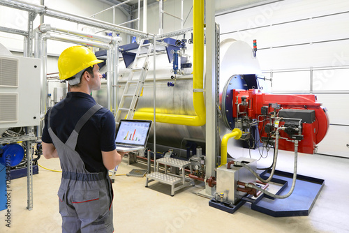 Wartung in einer Industrieanlage: Arbeiter checkt das System auf Funktion photo