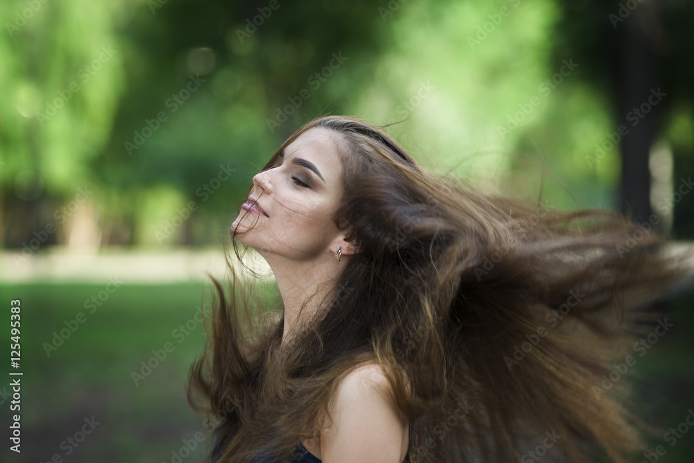 Naklejka premium Portrait of a beautiful young caucasian woman with flying long hair, clean skin and casual makeup