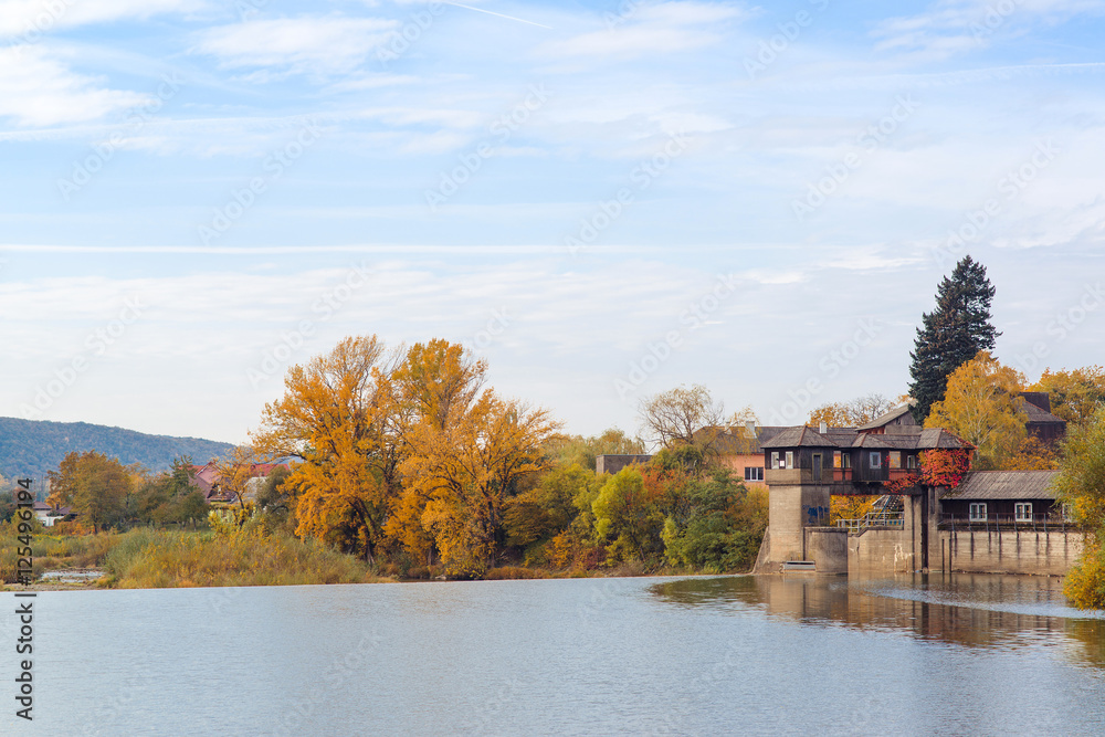 Fototapeta premium Autumn river , colorful trees near the water in village.