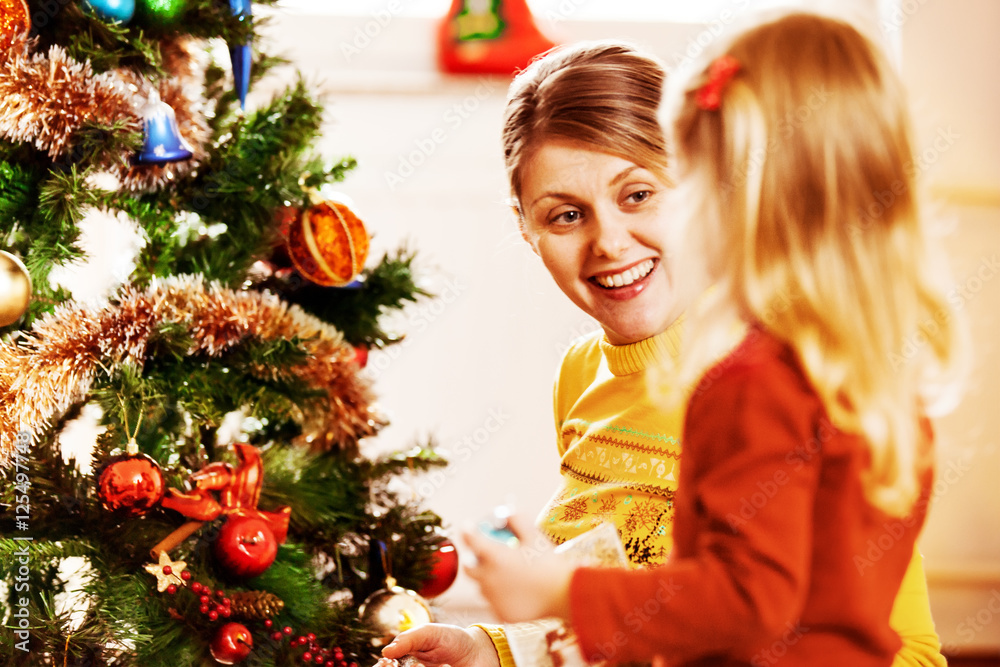 Happy family enjoying decorating Christmas tree.