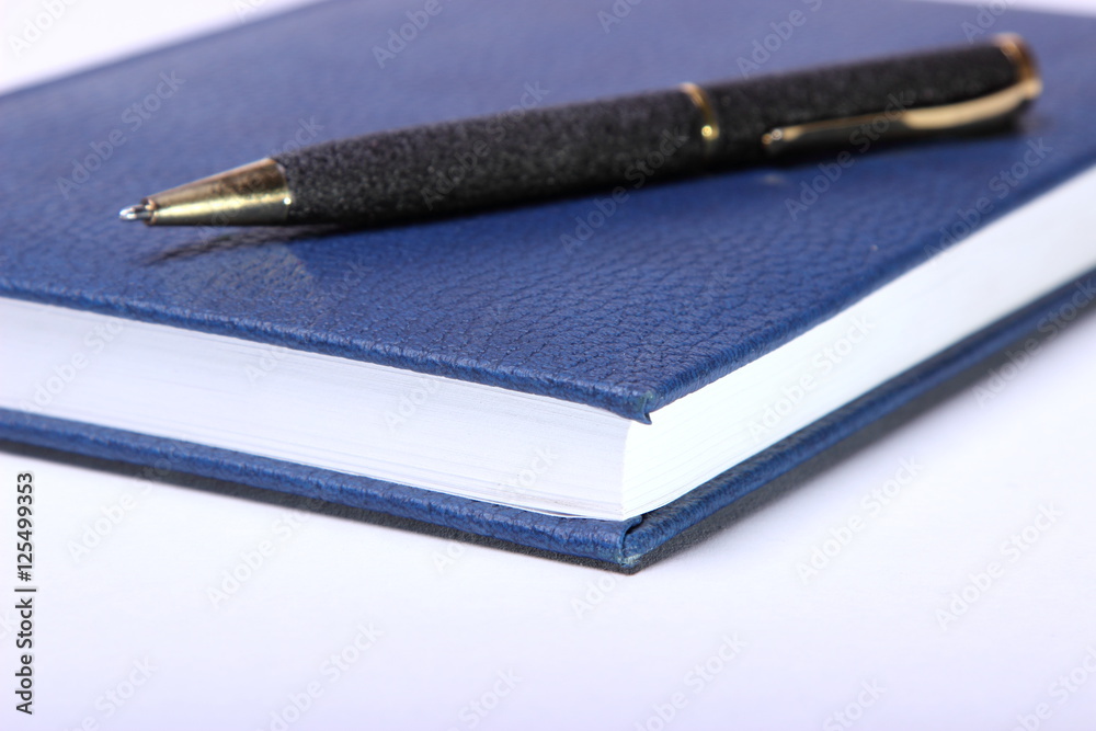 black ballpoint pen lying on a notebook