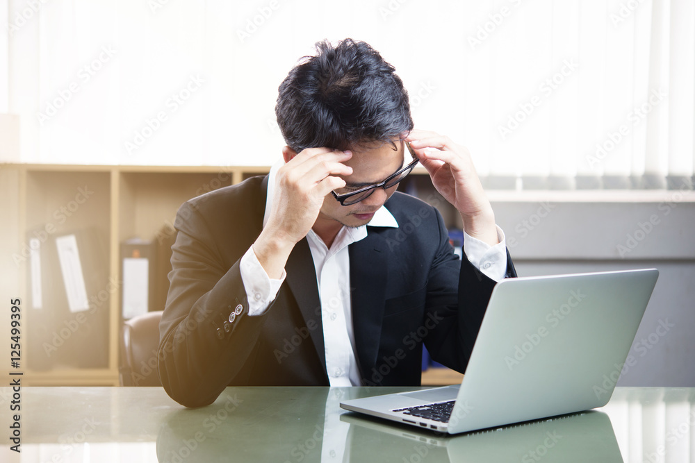 stressed businessman with laptop sitting at table in office stressed businessman with laptop sitting at table in office