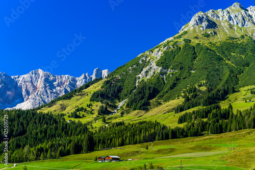 Beautiful alpine summer landscape. Mountains and sun, blue sky,