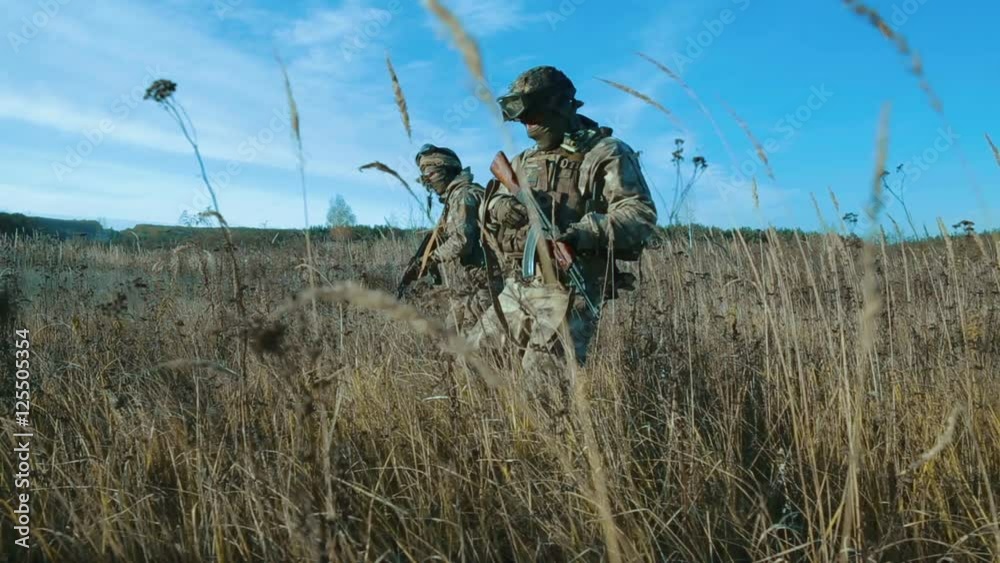 Ukrainian soldier walk on the field.
