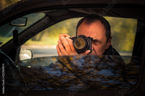 undercover man hidden in car take photo photo